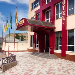 un ingresso dell'hotel con bandiere di fronte a un edificio di City Club a Charkiv