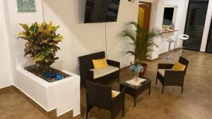 a living room with chairs and plants on a wall at Casa de Playa moderna in Lima