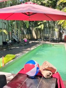 - une piscine avec un ballon de plage et un parasol dans l'établissement Suites Galván centro Colima, alberca, Wifi, parking, à Colima