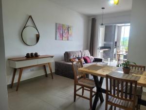 a living room with a table and a couch at APARTAMENTO PRÓXIMO A PRAIA PISCINA E AREA GOURMET in Ubatuba