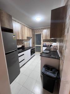 a kitchen with stainless steel appliances and wooden cabinets at الشيخ زايد in Cairo