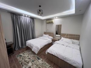 ein Hotelzimmer mit 2 Betten und einem Spiegel in der Unterkunft الشيخ زايد in Kairo