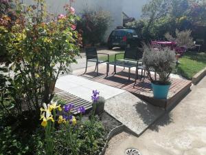 un jardín con 2 sillas, una mesa y flores en Logement+parking proche métro - total autonome, en Villejuif