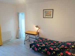 1 dormitorio con 1 cama y 1 mesa con lámpara en Logement+parking proche métro - total autonome, en Villejuif