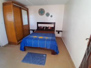 a bedroom with a bed with a blue comforter at Casa Djoko in Dakar