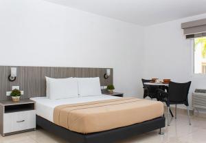 a bedroom with a bed and a desk and a table at Hotel Kariña Guanipa in San José de Guanipa