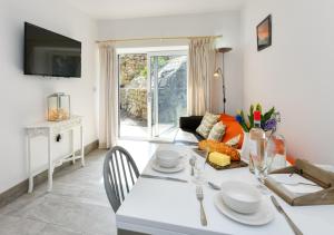 a dining room with a white table and chairs at Y Cwtch in Llanbedrog