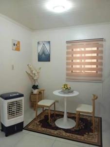 a room with a table and two chairs and a heater at Trails of Maia Alta Staycation in Antipolo
