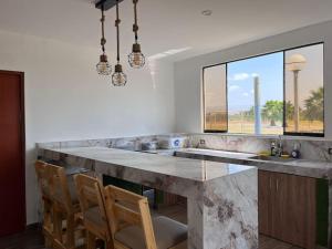 a kitchen with a large marble counter and chairs at Casa de Campo en Cañete in Imperial