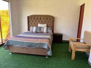 1 dormitorio con 1 cama grande y 1 silla en Casa de Campo en Cañete, en Imperial