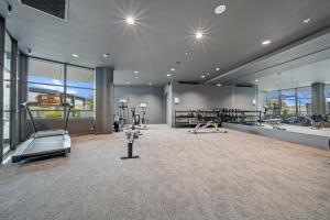a gym with treadmills and machines in a room at Comfy 1-Bed Apt with Courtyard, Gym, BBQ & Parking in Kingston 