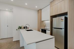 a kitchen with a white counter and a refrigerator at Comfy 1-Bed Apt with Courtyard, Gym, BBQ & Parking in Kingston 