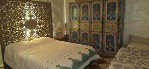- une chambre avec un lit et une grande armoire en bois dans l'établissement DAR SARSAR airport, à Marrakech