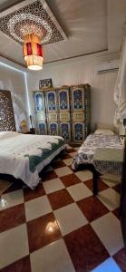 sypialnia z 2 łóżkami i podłogą wyłożoną szachownicą w obiekcie DAR SARSAR airport w Marakeszu