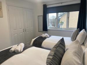 1 dormitorio con 2 camas y ventana en E.C.A.S. Pitreavie Castle 2 Bed Executive Apartment, en Fife