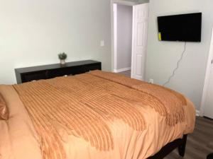 a bedroom with a bed and a flat screen tv at Queen Suite Indoor Hot Tub Wifi in Atlanta