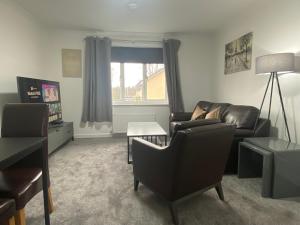 sala de estar con sofá y silla en E.C.A.S. Pitreavie Castle 2 Bed Executive Apartment, en Fife