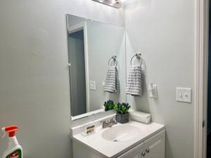 a white bathroom with a sink and a mirror at Queen Suite Outdoor Hot Tub Wifi Room 2 in Atlanta