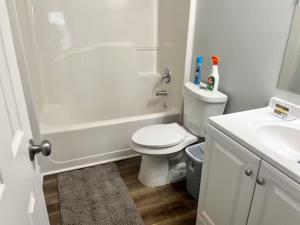 a white bathroom with a toilet and a sink at Queen Suite Outdoor Hot Tub Wifi Room 2 in Atlanta
