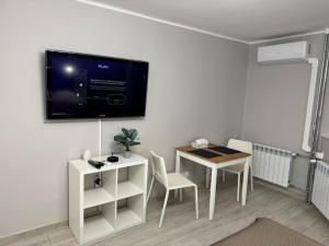uma sala de estar com uma mesa e uma televisão na parede em PRZYSTANEK KATOWICE Aleja Korfantego 8 em Katowice