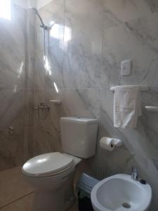 Baño blanco con aseo y lavamanos en Devoto Rentals en Buenos Aires