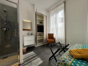 1 dormitorio con ducha, 1 cama y baño en Maison à la Guitarde - Hôtel Particulier Hippolyte, en Châteauroux