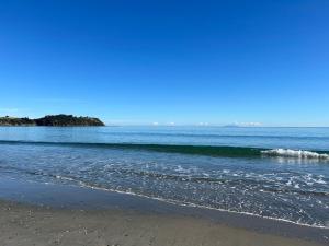 una playa con una pequeña ola en el océano en Whisper Cottage, en Onetangi