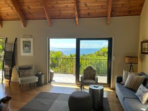 a living room with a view of the ocean at Whisper Cottage in Onetangi