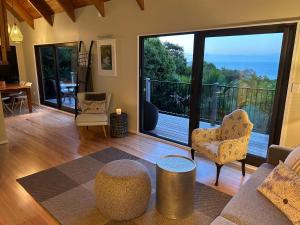 a living room with a view of a balcony at Whisper Cottage in Onetangi