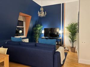Sala de estar azul con sofá y TV en Pimlico - Central London with City Views en Londres
