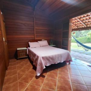 a bedroom with a bed in a wooden room at Chácara Flores de Maio in Atibaia