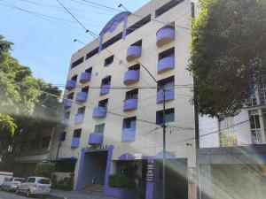 un edificio con balcones azules en su lateral en Hotel Max, en Ciudad de México