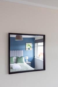 a mirror reflecting a bedroom with a bed and a window at Winton House in Glasgow