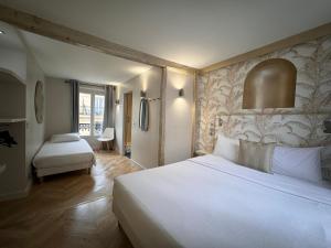 um quarto com uma grande cama branca num quarto em Hotel Nation Montmartre em Paris