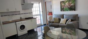 una sala de estar con un sofá y una mesa en Ático en arenas de malaga, en Arenas
