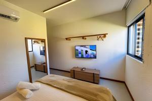 a bedroom with a large bed and a mirror at Refúgio em Condomínio Resort na Rota dos Milagres in Pôrto de Pedras