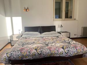 een slaapkamer met een groot bed met een kleurrijke deken bij Casina in Bellagio