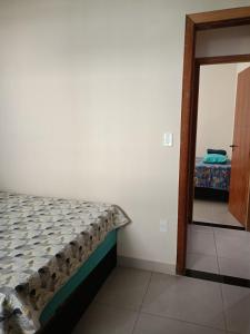 a bedroom with a bed and a door leading into a room at Apartamento para temporada in Vitória