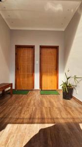ヴィトーリアにあるApartamento para temporadaの木の扉2つと鉢植えの植物がある部屋