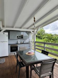 eine Küche mit einem Tisch und Stühlen auf einer Terrasse in der Unterkunft Villa citron in Ducos