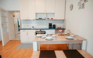 een keuken met een tafel met borden erop bij Raimond Apartment Top 27 in Wenen