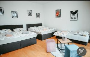 een kamer met drie bedden en een tafel bij Raimond Apartment Top 27 in Wenen