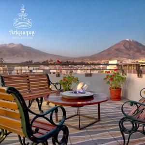 eine Terrasse mit einem Tisch, Stühlen und Bergen in der Unterkunft ARIQUEPAY HOTEL in Arequipa