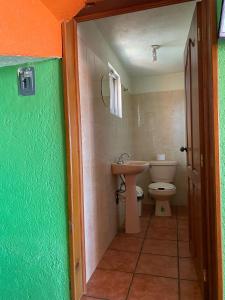 y baño con aseo y lavamanos. en Cabañas y Habitaciones El Malecón, en Zirahuén