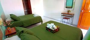 a living room with two beds and a table at Posada Nacha`n - Ka`an in Palenque
