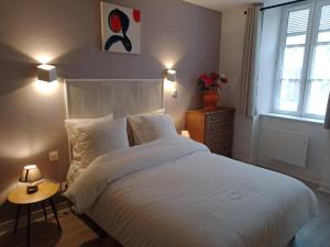 Un dormitorio con una gran cama blanca y una ventana en Appartement Eden, en Saint-Père