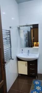 a white bathroom with a sink and a mirror at Pink Quest House in Lankaran
