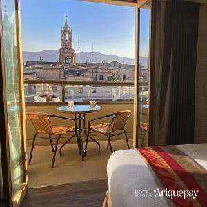 balcón con mesa, sillas y vistas a la ciudad en ARIQUEPAY HOTEL, en Arequipa