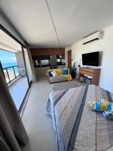 een slaapkamer met een bed en een woonkamer met uitzicht bij Studio luxo na Barra para 4 Pessoas in Salvador