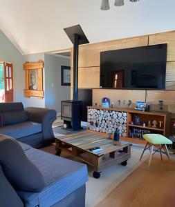 sala de estar con sofá y chimenea en Casa Rural con opción de tina temperada, en Puerto Varas